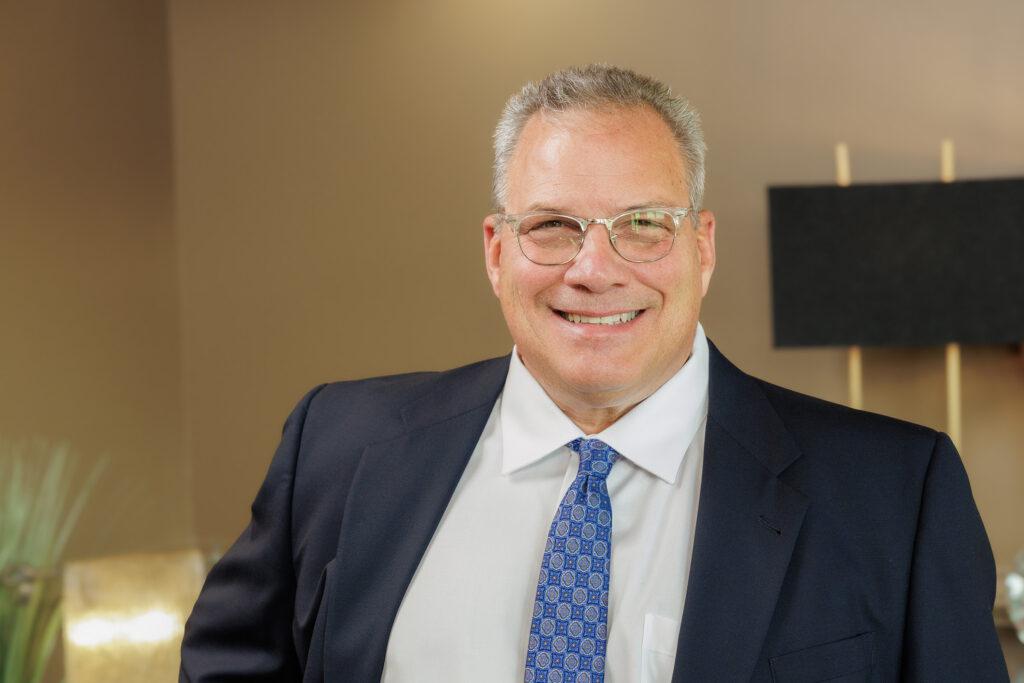 Smiling man in a suit and tie with glasses